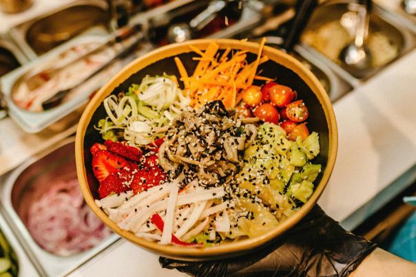 Poke bowl being made behind the county with fresh ingredients