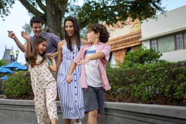 A family dancing in a theme park.