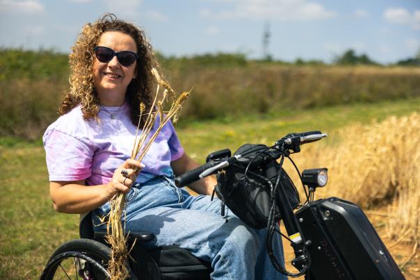 Carrie-Ann Lightley in a mobility scooter holding corn.