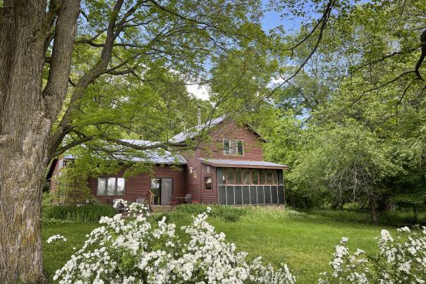 Artha Sustainable Living Center Bed and Breakfast surrounded by summer tree and flowers