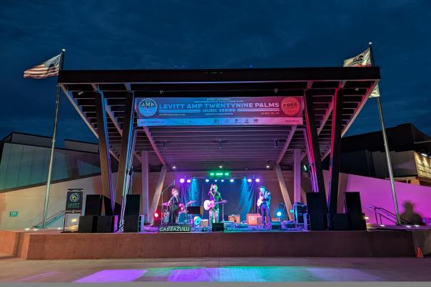 Musicians perform under colorful stage lights at Freedom Plaza during the Levitt AMP Twentynine Palms Fall Concert Series.