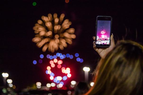 Woman taking photo of fireworks in Westgate