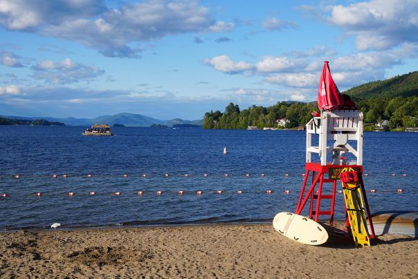 Lifeguard chair on the beach facing Lake George and Adirondack Mountains