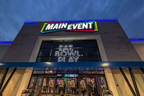 Main Event preview opening in Woodbury showing exterior signs lit up with "Eat. Bowl. Play"