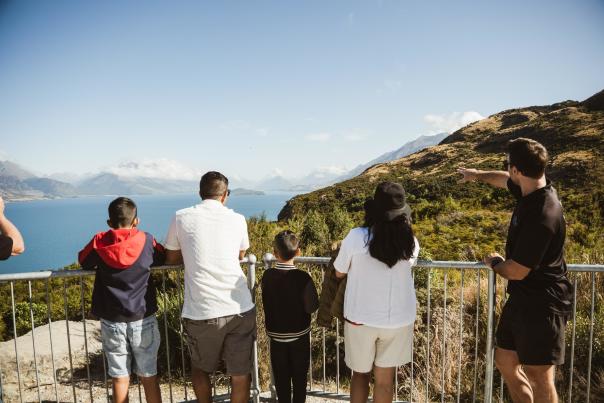 A family looking out from Bennetts Bluff Viewpoint Walk towards Glenorchy on a blue bird day with Altitude Tours