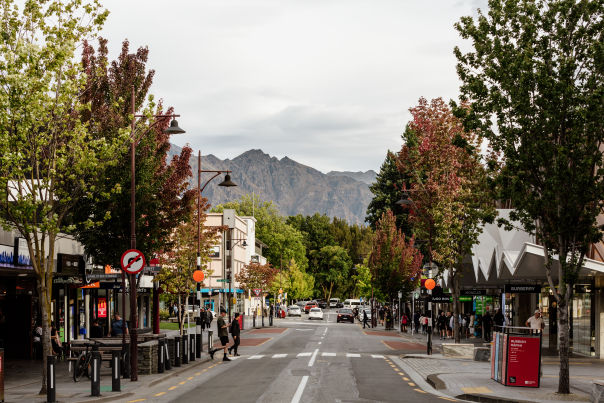 Queenstown town road with colourful trees and mountain in the background