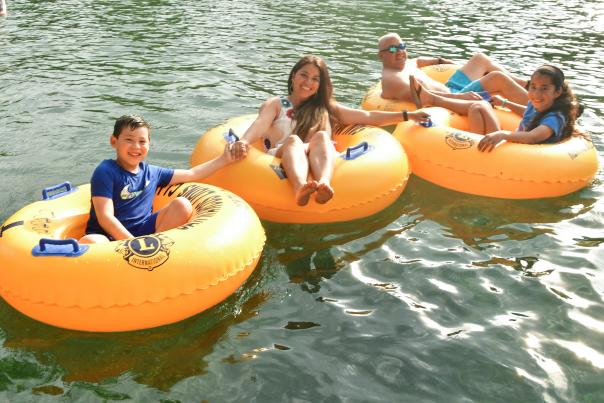 Family with two kids tubing on river