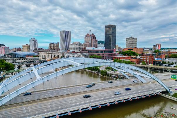 Photo of downtown Rochester, NY city skyline including clouds, bridge and downtown buildings