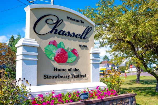 A sign reads "Welcome to Chassell" with pictures of strawberries.