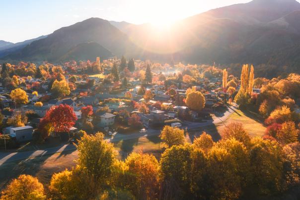 Aerial photo of Arrowtown full of gold and red trees in Autumn