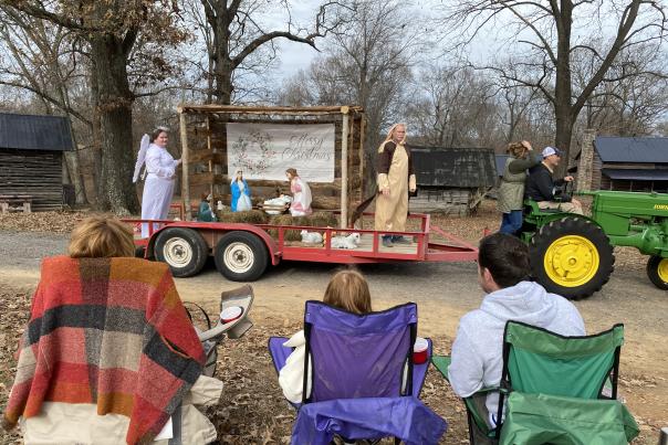 people watching a parade with a nativity in a rural setting