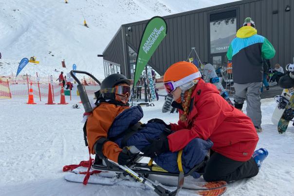 Two people couching down on the snow