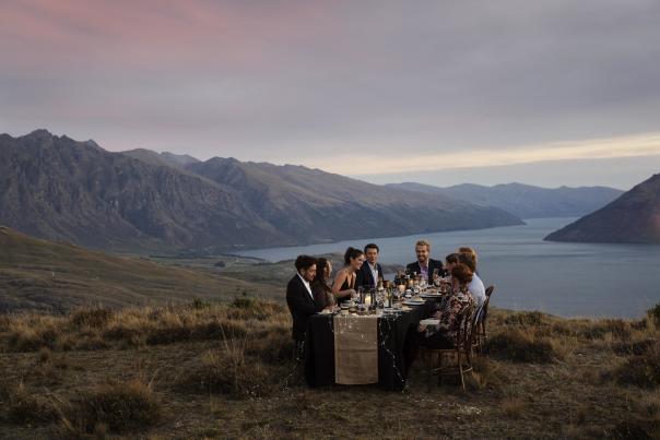 group dining on top of mountain with the Remarkables in the background