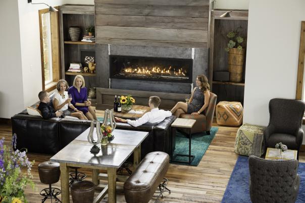Group of people sitting around Stone Tower Winery's cozy fireplace and inviting seating area in Leesburg Virginia.