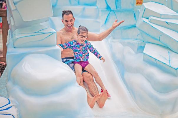 A father and daughter enjoy a slide at Aquatopia Indoor Waterpark at Camelback Resort in the Poconos.