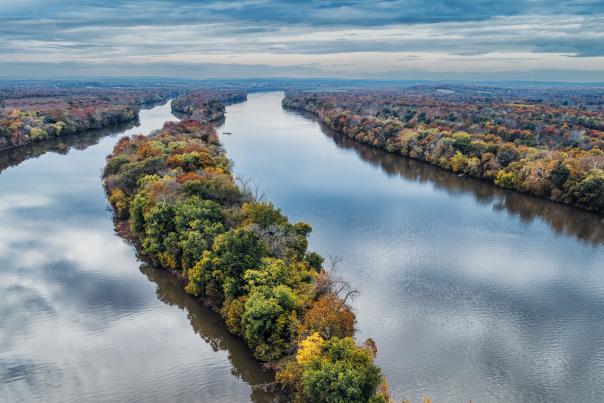 Fall foliage along the Potomac River and a tree-covered island seen from aerial view at Algonkian Regional Park in Sterling