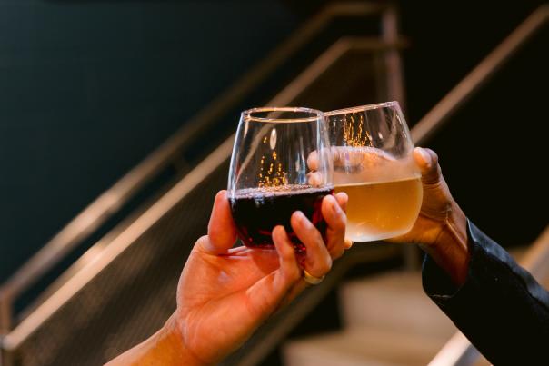 Wine glasses cheersing in front of the North Market Bridge Park sign