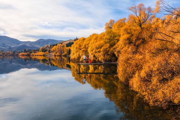 People on a pier at Lake Hayes in Autumn