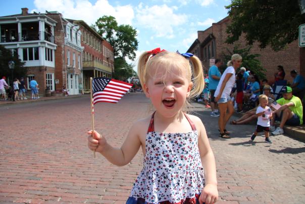 Kid at Riverfest Parade, waving flag