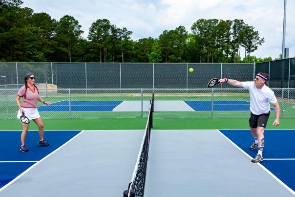 Two people playing pickleball on outdoor courts in Greater Fayetteville, NC