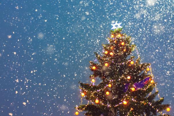 Illuminated Christmas tree at night with falling snow