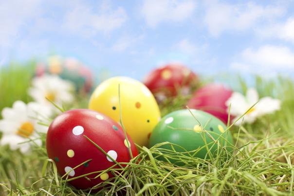 A closeup of decorated Easter eggs laying in the grass