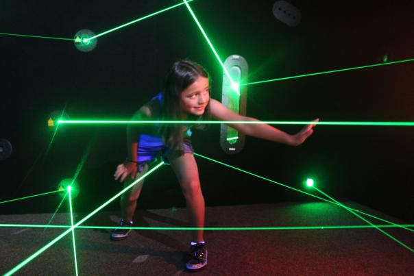 Young Girl Tries to Make Her Way Through the Green Pointed Lasers