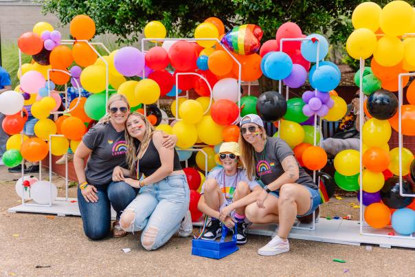 A group of people pose in front of a baloon Pride sign during the Annapolis Pride Parade