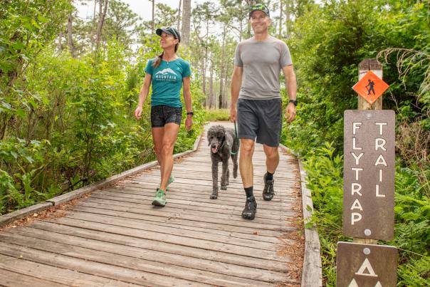 Couple walking with dog at Carolina Beach State Park  on Flytrap Trail