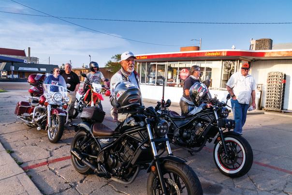 Group of people stand by motorcycles