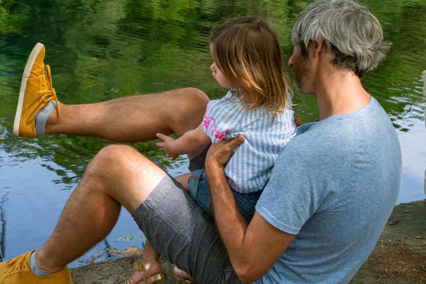 Dad and daughter playing by river