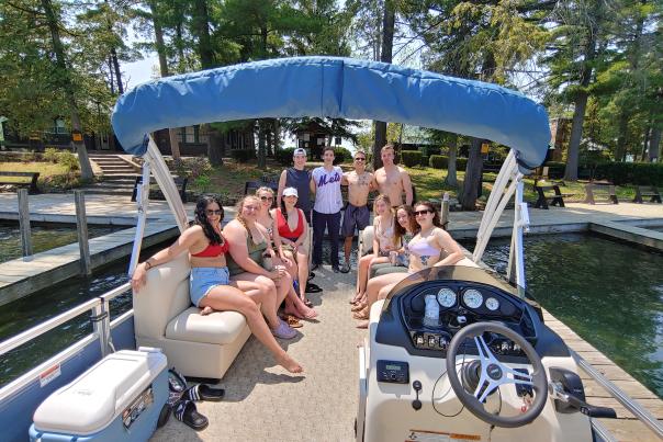 Group of people posing on the back of a docked pontoon