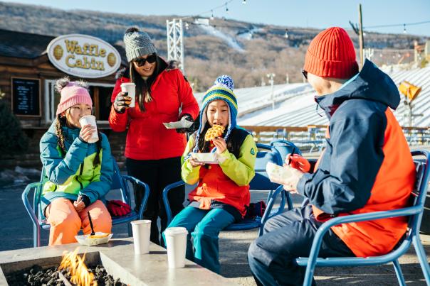 A family enjoys waffles by the ski slopes at Camelback Mountain.