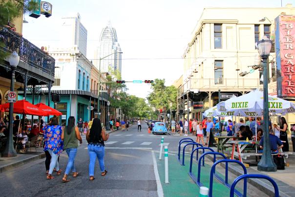 group of people walking down Dauphin Street