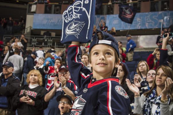 Young boy cheering on Columbus Blue Jackets with foam finger