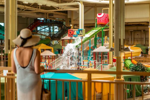 Woman in a floppy sun hat looking at the OKANA Indoor Waterpark