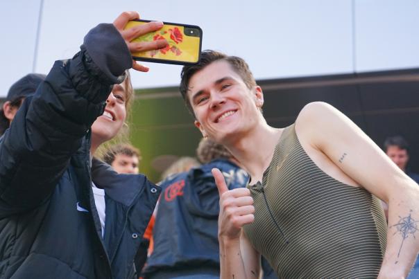 A fan takes a selfie with an athlete at Hayward Field