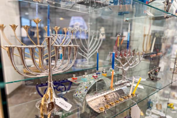 Several menorahs line the shelves at Sisterhood Judaica Gift Shop