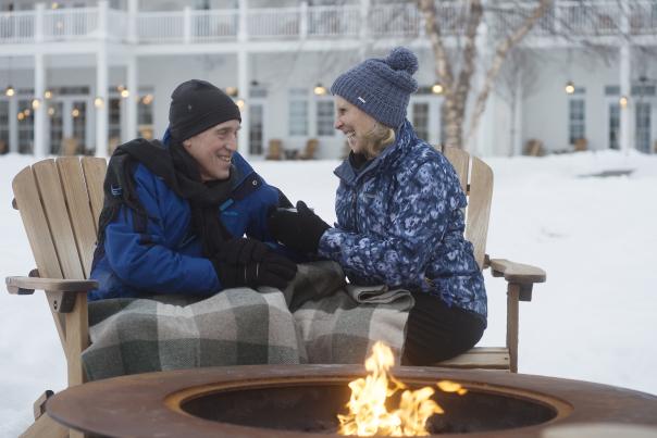 A couple enjoying the firepit by the water