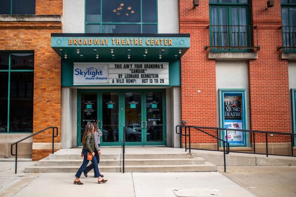 Two people walking in front of Broadway Theatre Center, home of Skylight Music Theatre