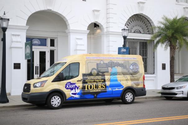 colorful passenger van parked in front of white building