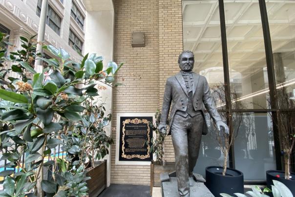 A bronze statue depicting William Alexander Leidersdorff, an African American man dressed in an 1800s suit, striding toward the viewer
