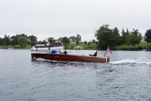 A wooden boat and the Judge Ben Wiles boat of Mid-Lakes Navigation cross paths on Skaneateles Lake before the Skaneateles Antique & Classic Boat Show.
