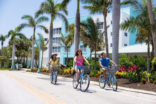 Three people riding blue bikes on Manasota Key courtesy Manasota Key Resort