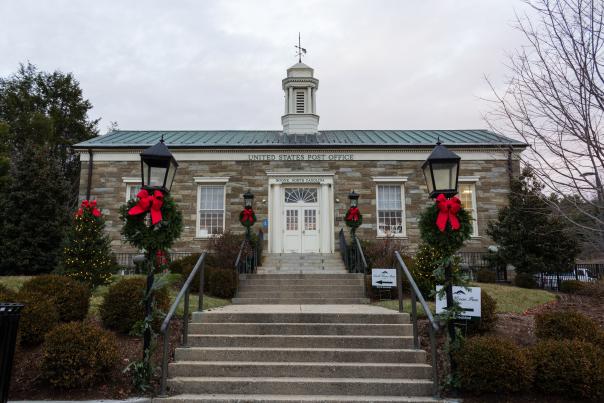 The Historic Boone post office is decorated with wreaths on each lamppost next to the stairs.