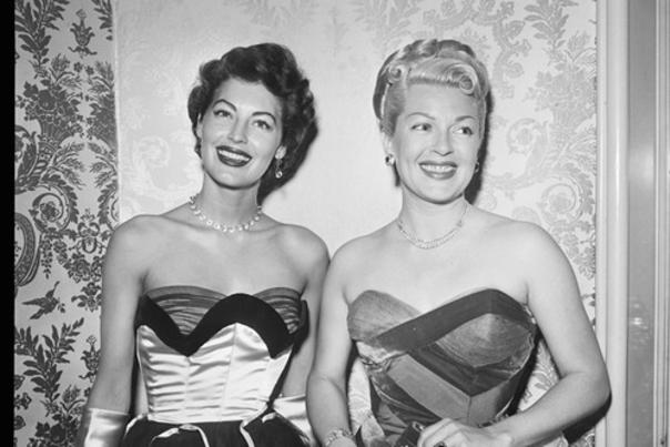 Ava Gardner and Lana Turner dressed in party dresses at the Ribbon ball
