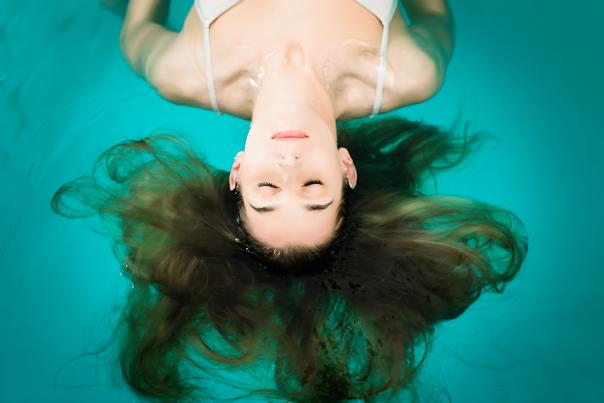 Woman floating on her back in a water tank