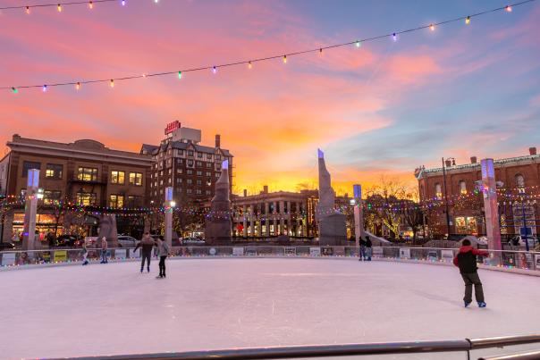 sunset over downtown rapid city south dakota as families ice skate at main street square with christmas lights