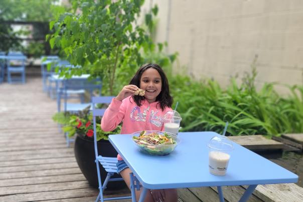 A child eating food on a patio