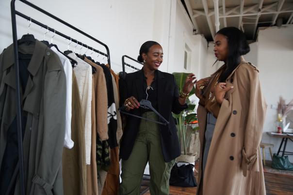 Two women trying clothes on from clothing rack